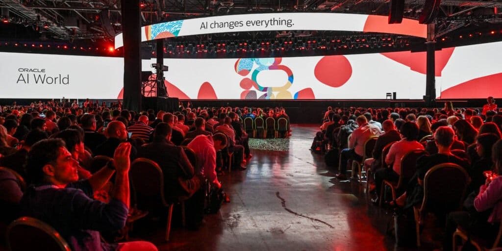 Audience seated beneath the AI World stage screens