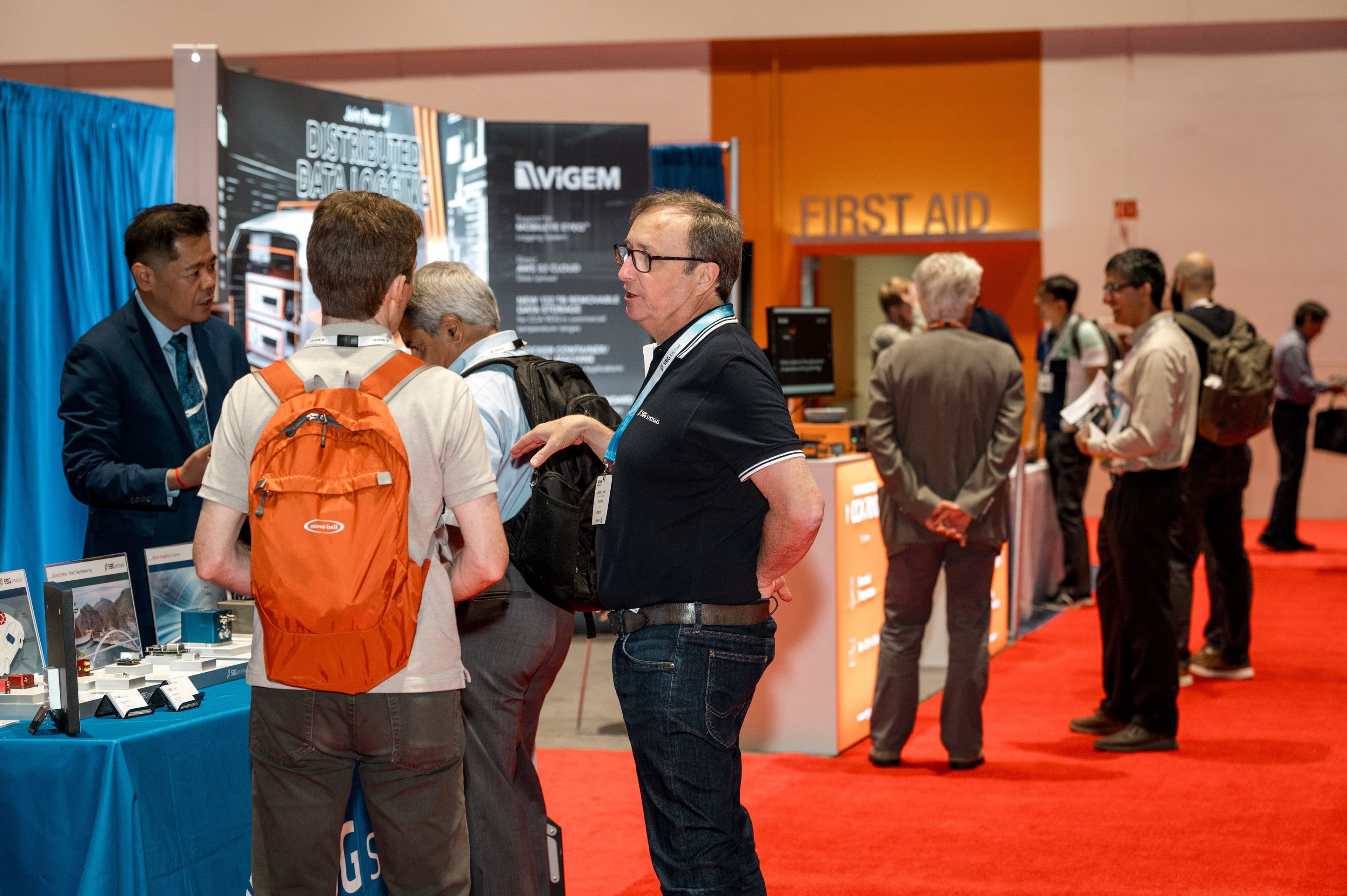 Visitors speak with exhibitors on the vehicle technology show floor