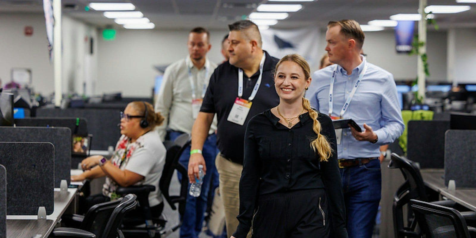 ICMI Contact Center Expo attendees walk through a live contact center during an operations tour.