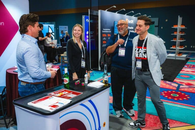 InfoSec World 2025 attendees talking beside an expo booth