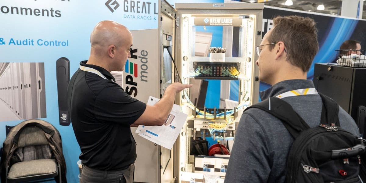 Exhibitor speaking with attendees at an ISC East booth in 2023