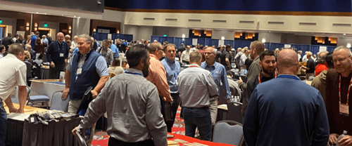 Dealers and suppliers speak beside exhibit tables at LMC Expo 2023