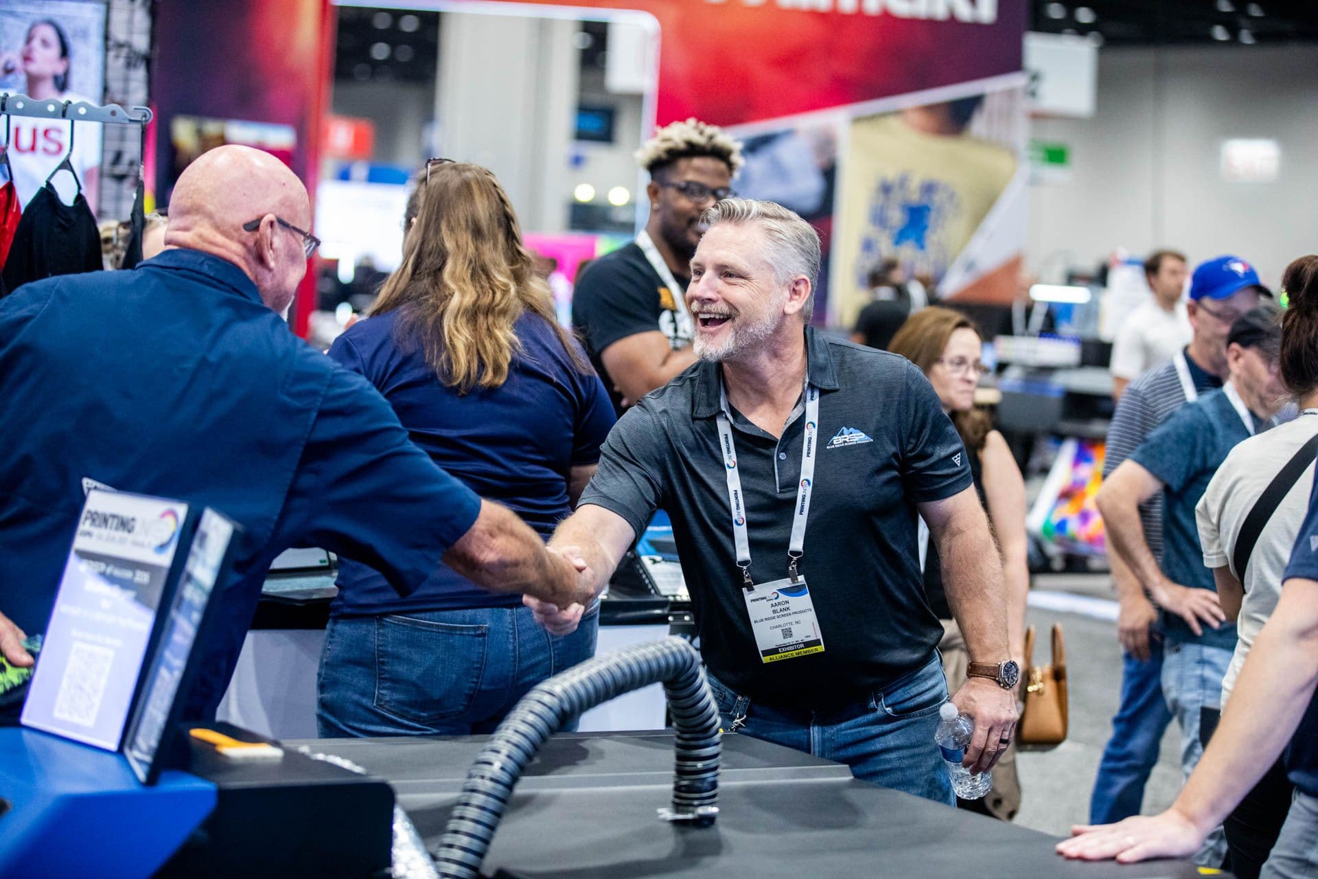 PRINTING United Expo attendees discussing products on the show floor