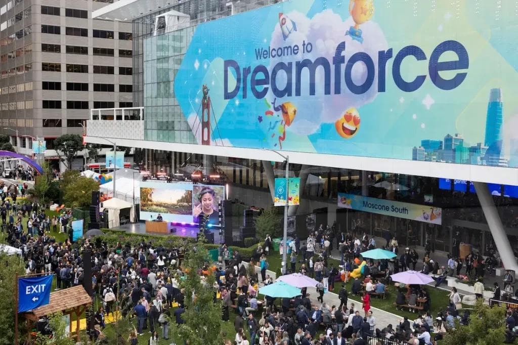 Dreamforce 2026 attendee taking selfie with Salesforce mascot in Fisher & Parker park area