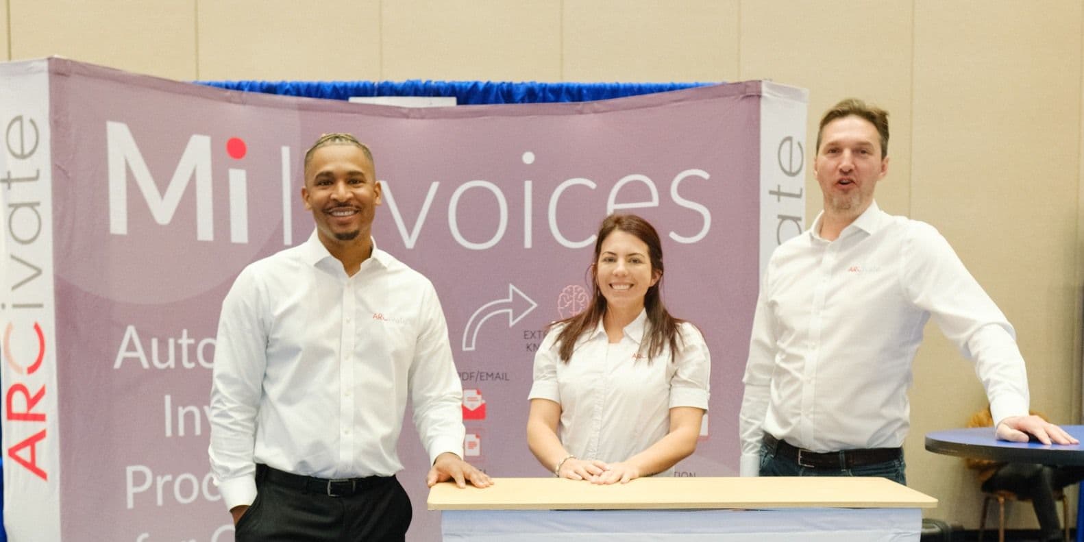 Three Arcivate staff members beside their booth at IOFM Fall 2024.