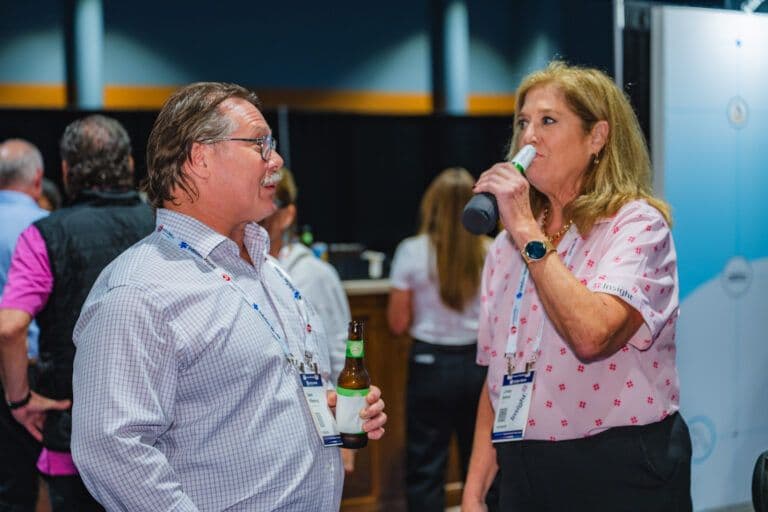 Two InfoSec World 2025 attendees talk during a reception